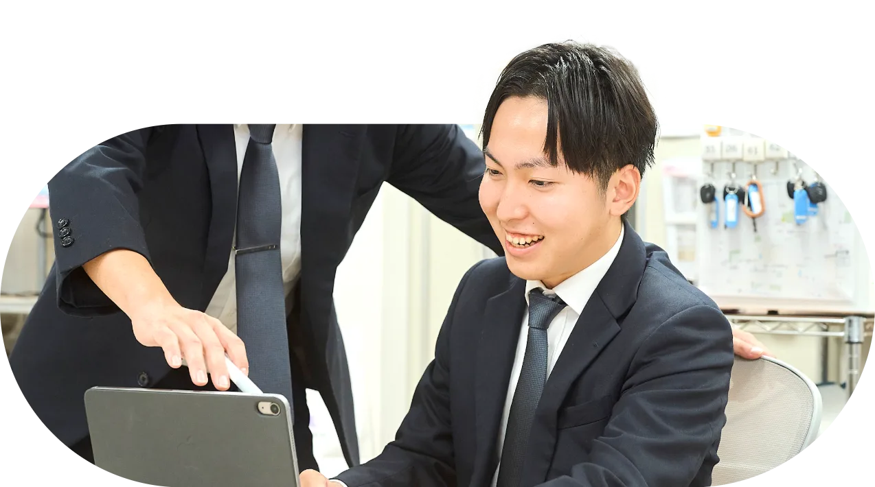 先輩社員とタブレットを確認する社員