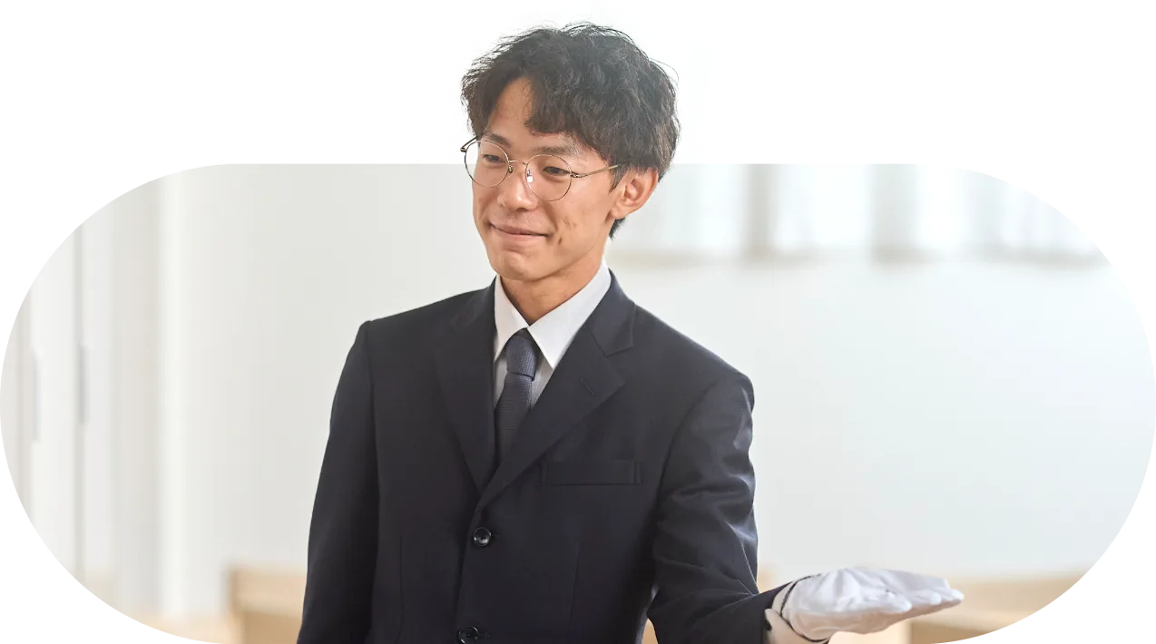 白い手袋をつけて式場を案内する社員